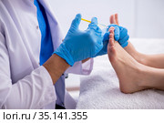 Podiatrist treating feet during procedure. Стоковое фото, фотограф Elnur / Фотобанк Лори