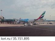 Самолет авиакомпании Emirates Airlines у перрона в международном аэропорту. Милан, Италия (2019 год). Редакционное фото, фотограф Вадим Хомяков / Фотобанк Лори