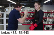 Boxing coach shows the punch technic to his woman trainee. Стоковое видео, видеограф Константин Шишкин / Фотобанк Лори