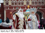 Дед Мороз и Снегурочка поздравляют людей с наступающем Новым годом на Манежной площади в центре города Москвы в предновогодние дни, Россия (2012 год). Редакционное фото, фотограф Николай Винокуров / Фотобанк Лори