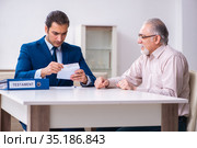 Young male lawyer visiting old man in testament concept. Стоковое фото, фотограф Elnur / Фотобанк Лори