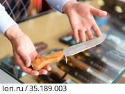 Hunting skinner knife in hands of gun shop seller. Стоковое фото, фотограф Яков Филимонов / Фотобанк Лори