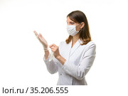 Девушка врач натягивает прозрачные медицинские перчатки на руки. Стоковое фото, фотограф Иванов Алексей / Фотобанк Лори
