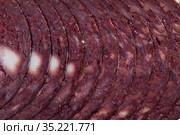 Close up of Spanish smoked blood sausage on white plate on wooden table. Стоковое фото, фотограф Яков Филимонов / Фотобанк Лори
