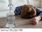 A drunk woman with shot of vodka and a decanter lies face down on the table. Стоковое фото, фотограф Володина Ольга / Фотобанк Лори