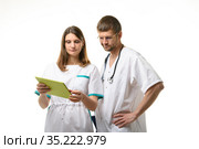 Доктор и медсестра обсуждают анализы пациента, с задумчивостью смотря в экран планшетного компьютера. Стоковое фото, фотограф Иванов Алексей / Фотобанк Лори