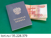 Трудовая книжка и российские деньги на столе. Выплаты по трудовому договору. Стоковое фото, фотограф Наталья Осипова / Фотобанк Лори