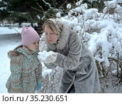 Молодая женщина с дочкой играют со снегом в зимнем парке. Стоковое фото, фотограф Ирина Борсученко / Фотобанк Лори