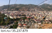 Ropeway car ascending over the city. Mountain ropeway connects city and Alanya castle, cityscape from the cabin of cableway close to the Kleopatra beach. The Alanya, Turkey (2021 год). Стоковое видео, видеограф Кекяляйнен Андрей / Фотобанк Лори