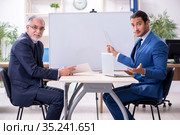 Yound and old employees in business presentation concept. Стоковое фото, фотограф Elnur / Фотобанк Лори