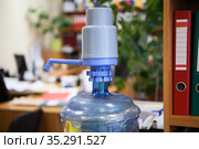 Water dispenser bottle with plastic hand pump standing in an office room. Стоковое фото, фотограф Кекяляйнен Андрей / Фотобанк Лори