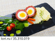 Dish scotch egg with tomatoes, mashed potatoes and greens, traditional Scottish cuisine. Стоковое фото, фотограф Яков Филимонов / Фотобанк Лори