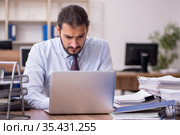 Young businessman employee unhappy with excessive work in the of. Стоковое фото, фотограф Elnur / Фотобанк Лори