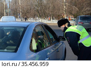 Инспектор дорожно-патрульной службы полиции разговаривает с водителем остановленного автомобиля (2016 год). Редакционное фото, фотограф Free Wind / Фотобанк Лори