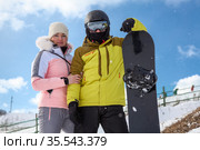 Couple of snowboarders, portrait with snowboard, persons wearing ski equipment. Стоковое фото, фотограф Кекяляйнен Андрей / Фотобанк Лори