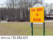 Табличка "Парк закрыт на просушку". Объявление крупно на фоне территории. Весна, Россия Park is closed on drying (2021 год). Редакционное фото, фотограф Grigory_Gez / Фотобанк Лори