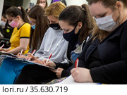 Участники ежегодной образовательной акции "Тотальный диктант - 2021" пишут диктант по русскому языку в благотворительной организации "Ночлежка" города Москвы, Россия. Редакционное фото, фотограф Николай Винокуров / Фотобанк Лори