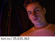Portrait of attractive young man in neon lighting. Стоковое фото, фотограф Женя Канашкин / Фотобанк Лори