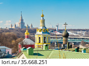 Вид на Андреевский монастырь и главное здание Московского Государственного Университета имени Ломоносова (МГУ) на Воробьевых горах. Весенний день. Москва (2021 год). Редакционное фото, фотограф E. O. / Фотобанк Лори