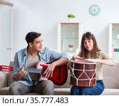 Young family singing and playing music at home. Стоковое фото, фотограф Elnur / Фотобанк Лори