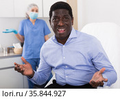 Dissatisfied male patient after cosmetic procedures in aesthetic clinic. Стоковое фото, фотограф Яков Филимонов / Фотобанк Лори