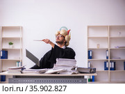 Funny young male employee magician and too much work in the office. Стоковое фото, фотограф Elnur / Фотобанк Лори