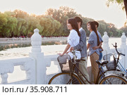 Two couples by HouHai Lake with Bicycles in Beijing. Стоковое фото, агентство Ingram Publishing / Фотобанк Лори