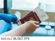 Closeup of female holding passports and boarding pass at airport. Стоковое фото, фотограф Константин Лабунский / Фотобанк Лори