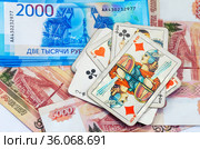 Азартные игры на деньги. Игральные карты на фоне российских купюр достоинством 2000 и 5000 (2 и 5 тысяч) рублей. Стоковое фото, фотограф Grigory_Gez / Фотобанк Лори