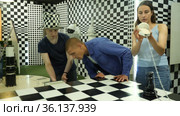 Portrait of a brooding family trying to find a solution to a puzzle in the confined space of a lost room. Стоковое видео, видеограф Яков Филимонов / Фотобанк Лори