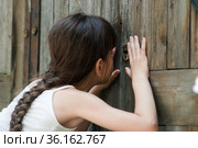Девочка подсматривает в замочную скважину. Стоковое фото, фотограф WalDeMarus / Фотобанк Лори