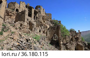 Ruins of ancient Gamsutl village with abandoned building stone walls at the top of the mountain peak against blue sky in Dagestan, Russia (2021 год). Стоковое видео, видеограф Алексей Кузнецов / Фотобанк Лори
