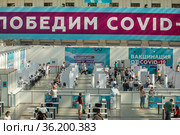 Люди в пункте вакцинации от COVID-19 в Гостином дворе в центре города Москвы, Россия (2021 год). Редакционное фото, фотограф Николай Винокуров / Фотобанк Лори
