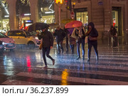 Люди переходят улицу под проливным дождем. Париж, бульвар Осман, декабрьский вечер. (2017 год). Редакционное фото, фотограф Сергей Рыбин / Фотобанк Лори