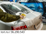 Мойщик натирает пеной автомобиль на мойке (2021 год). Редакционное фото, фотограф Игорь Низов / Фотобанк Лори