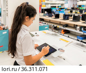 A schoolgirl girl tests a gadget in a store. Стоковое фото, фотограф Владимир Ушаров / Фотобанк Лори