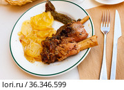 Calcots onions served on plate with Romesco sauce - traditional Catalan dish. Стоковое фото, фотограф Яков Филимонов / Фотобанк Лори