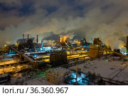 Aerial view of metallurgical plant blast furnace at night with smokestacks and fire blazing out of the pipe. Industrial panoramic landmark with blast furnance of metallurgical production. Стоковое фото, фотограф Евгений Ткачёв / Фотобанк Лори