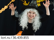 Веселая девочка в белом парике и  костюме ведьмы на черном фоне. Стоковое фото, фотограф Наталья Гармашева / Фотобанк Лори