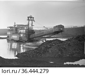 Горно-обогатительный агрегат стоит посреди небольшого водоёма, сооружение для золото добычи, пейзаж с установкой для извлечения полезных ископаемых из земли, Алданский район, Якутия, июнь 1965. Стоковое фото, фотограф Варфоломей Тетерин / Фотобанк Лори