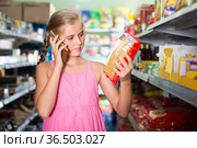 Girl is advised by phone what pasta she should buy. Стоковое фото, фотограф Яков Филимонов / Фотобанк Лори