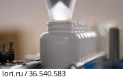 Фармацевтическое производство. Медицинские капсулы в упаковочной машине. Pharmaceutical production. Medical capsules are moving in a packaging machine. Стоковое видео, видеограф Евгений Романов / Фотобанк Лори