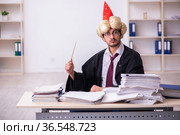 Funny young male employee magician and too much work in the office. Стоковое фото, фотограф Elnur / Фотобанк Лори