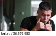 A man in sportive t-shirt shadow boxing in front of a camera. Стоковое видео, видеограф Константин Шишкин / Фотобанк Лори
