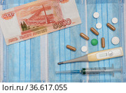 Российские деньги, медицинский градусник, шприц, таблетки и лекарства в ампулах на фоне из одноразовых масок. Стоковое фото, фотограф Цибаев Алексей / Фотобанк Лори