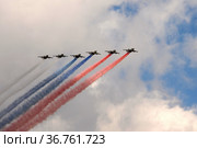 Группа штурмовиков Су-25 "Грач" дымят цветами российского флага в небе над Красной площадью во время генеральной репетиции парада, посвященного 76-летию Победы в Великой Отечественной войне (2021 год). Редакционное фото, фотограф Free Wind / Фотобанк Лори