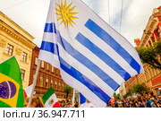 Russia, Samara, July 2019: a girl cheerleader holds the national flag of Uruguay in the procession of football fans on Kuibyshev street at the carnival dedicated to the World Cup. Редакционное фото, фотограф Акиньшин Владимир / Фотобанк Лори