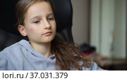 Little sad girl is sitting on black office chair, punishment, serious face. Стоковое видео, видеограф Ольга Балынская / Фотобанк Лори