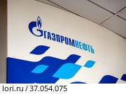 Логотип и название корпорации «Газпромнефть» на белом щите АЗС (2019 год). Редакционное фото, фотограф Светлана Попова / Фотобанк Лори