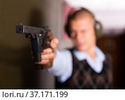 Smallbore sporting pistol in hand of man training in shooting range. Стоковое фото, фотограф Яков Филимонов / Фотобанк Лори